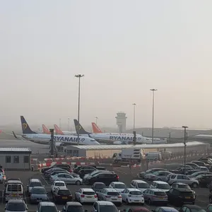 Parkplätze am Flughafen mit Flugzeugen im Hintergrund